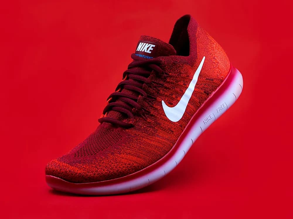Red running shoe against a flat red backdrop