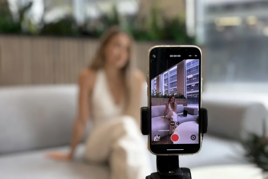 Creator filming herself on a phone mounted to a tripod