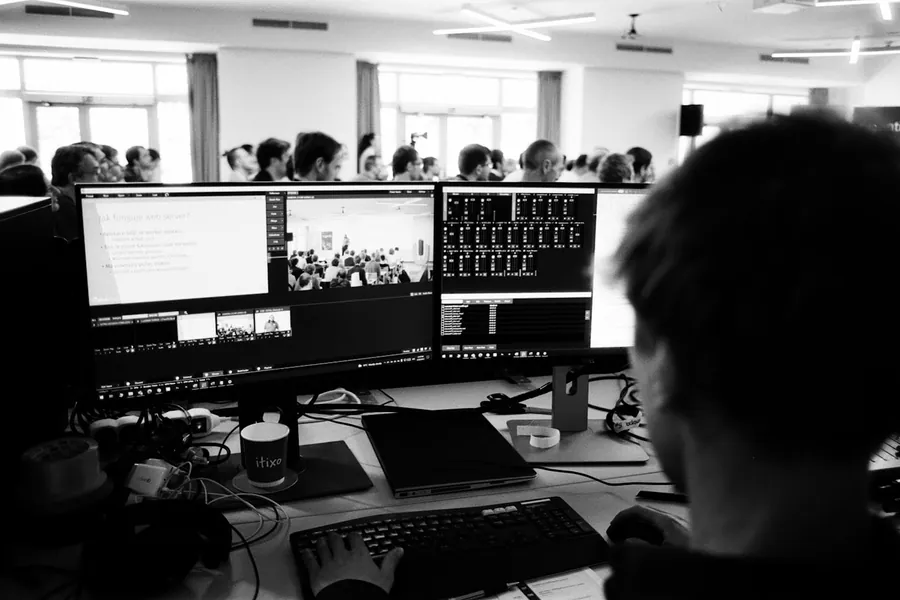 Editor at a multi-monitor bay working a video timeline